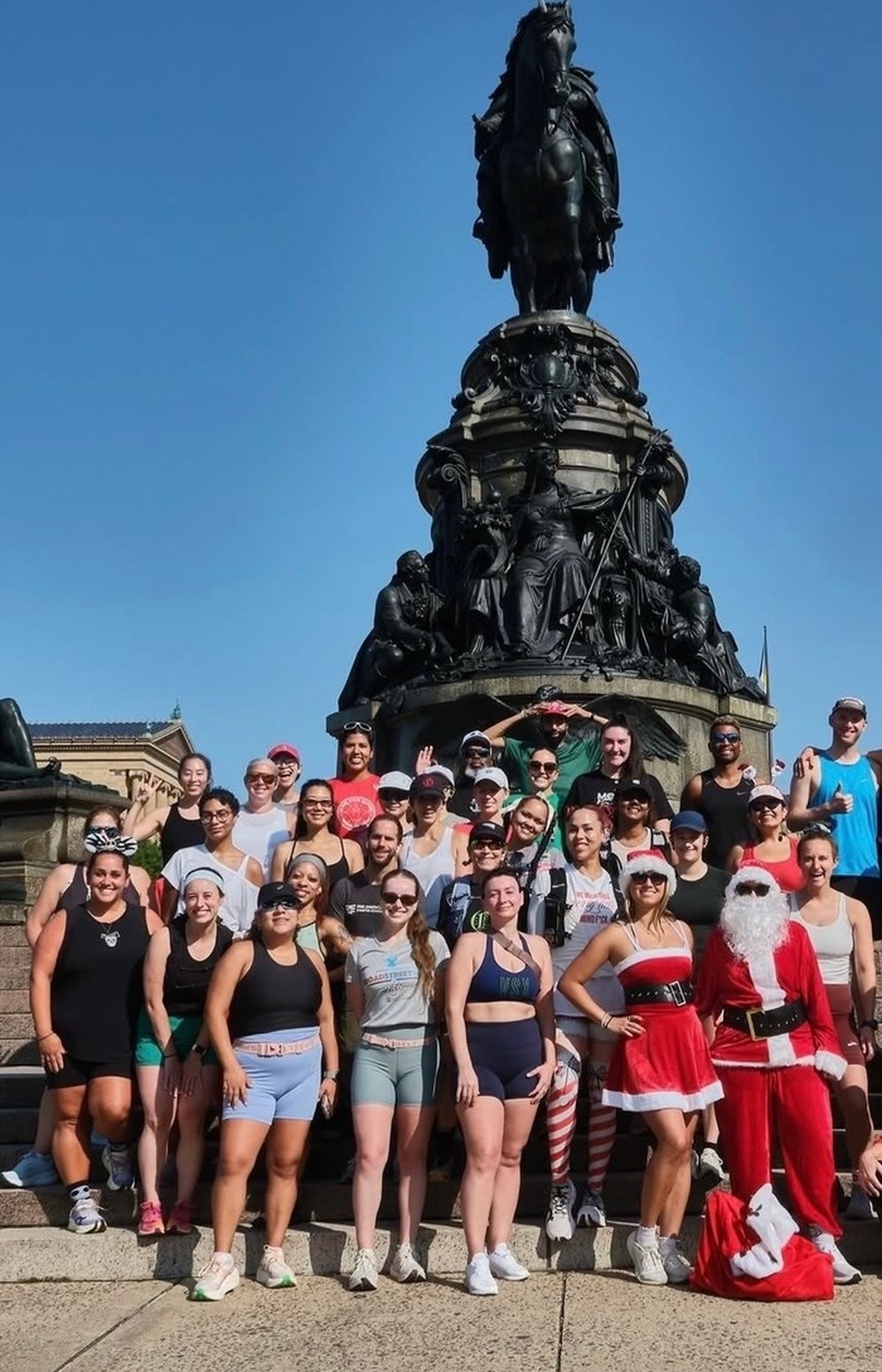 Diana Sparkles with a large run club group at the holiday run in front of the Washington Monument statue